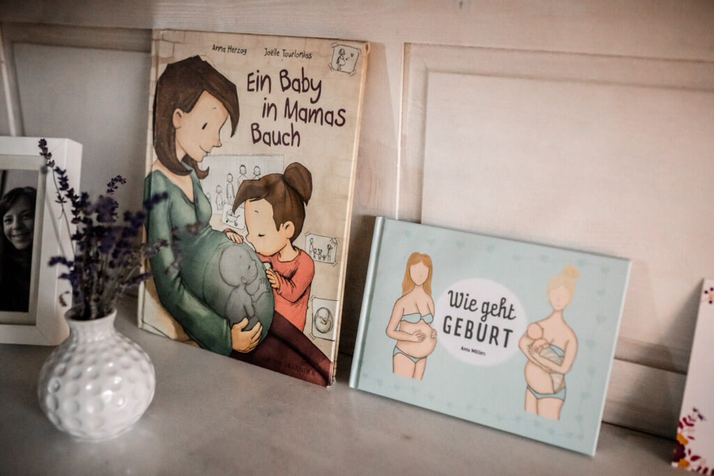 2 Kinderbücher zum Thema Geburt und Schwangerschaft stehen auf Kommode